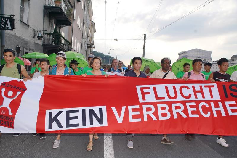 Menschen auf der Demonstration tragen ein Transparent mit der Aufschrift: Flucht ist kein Verbrechen